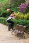 Вид збоку спортивна дівчина стрибає на лавці в парку — стокове фото