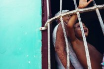 CUBA - AUGUST 27, 2016: Side view of smiling child and elder behind bars — Stock Photo