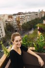 Basso angolo di vista sorridente ragazza bruna in occhiali in posa in terrazza — Foto stock