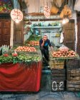 MOROCCO - AGOSTO 15: Jovem vendedor cansado em pé no balcão com romãs e verde no mercado . — Fotografia de Stock