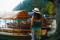 Rear view of brunette woman standing near moored boats — Stock Photo