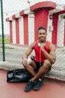 Smiling sportsman posing near fence after workout — Stock Photo