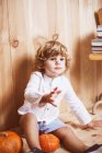 Чарівна дитина сидить на підлозі з гарбузами — стокове фото