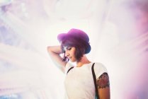 Seitenansicht einer Frau mit Hut, die im beleuchteten Nachtpark posiert — Stockfoto