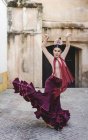 Vista frontal de la bailarina de flamenco con traje típico posando en el patio interior - foto de stock