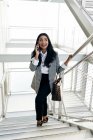 Businesswoman having phone conversation on stairs passage — Stock Photo