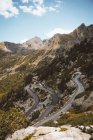 Picturesque view of mountains ridge with curvy road running down on slope. — Stock Photo