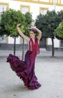 Flamenco-Tänzerin posiert mit erhobenen Händen am Stadtplatz — Stockfoto