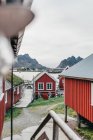 Екстер'єр червоних будинків у селі на гірському березі озера — стокове фото
