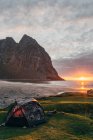 Paysage de la côte de l'océan scène de coucher de soleil avec tente sur la pelouse — Photo de stock