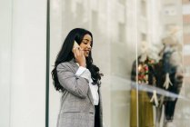 Vista laterale o donna d'affari che parla al telefono vicino alla vetrina — Foto stock