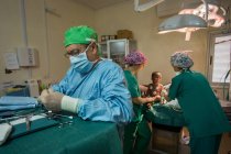 BENIN, ÁFRICA - 31 de agosto de 2017: Cirujano infantil se prepara para operar a un niño pequeño en el hospital . - foto de stock