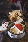 Still life of Christmas cookies in sauce pot and cinnamon sticks — Stock Photo