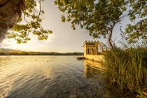 Vista panorámica de la orilla del lago con torre de piedra soleada - foto de stock