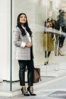 Full-length portrait businesswoman posing near shop window — Stock Photo