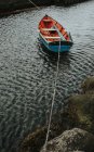 Barco de madeira amarrado flutuando na água na baía — Fotografia de Stock