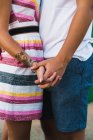 Crop side view of embracing couple holding hands — Stock Photo
