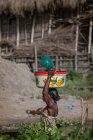 BENIN, AFRIQUE - 31 AOÛT 2017 : Vue de côté de la femme avec bol sur la tête — Photo de stock