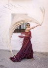 Flamenco dancer posing with shawl beside street wall with window — Stock Photo