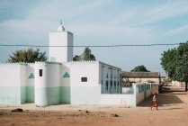 Goree, Sénégal- 6 décembre 2017 : Vue latérale de la promenade pédestre le long du bâtiment blanc sous un soleil éclatant
. — Photo de stock