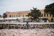 Goree, Senegal - 6 de diciembre de 2017: Retrato del mendigo sentado en la escena de la calle - foto de stock