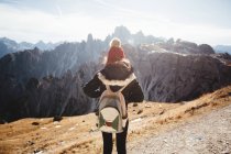 Unerkennbare Frau mit Rucksack genießt Bergblick an sonnigem Tag. — Stockfoto