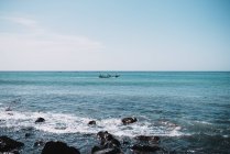Picturesque view of turquoise sea and distant boat sailing on sunny day. — Stock Photo