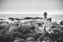 Freitag, 6. Dezember 2017: Porträt eines Mädchens, das am Meer auf Steinen steht. — Stockfoto