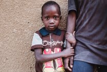 Goree, Senegal- Dezembro 6, 2017: Retrato de menino segurando a mão masculina e olhando para a câmera . — Fotografia de Stock