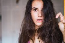 Portrait of brunette girl with wavy hair looking at camera — Stock Photo