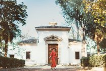 Seitenansicht einer rothaarigen Frau, die vor dem Hintergrund eines alten Gebäudes geht — Stockfoto