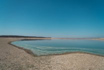 Сценический пейзаж береговой линии озера с бирюзовой водой — стоковое фото
