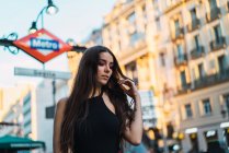 Portrait of brunette walking at street and waving hair — Stock Photo