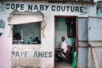 Goree, Senegal - 6 de dezembro de 2017: pessoas africanas sentadas e trabalhando em uma loja na cidade pobre . — Fotografia de Stock