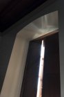 Vista ad angolo basso dei granelli di polvere attraverso la finestra alla luce del sole — Foto stock
