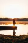 Silhouette on boat at lakeside in dawn haze — Stock Photo