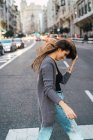 Вид збоку брюнетка дівчина махає волосся вулиця сцена — стокове фото
