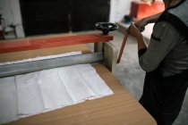 Crop image of artisan adjusting machine on table at workshop — Stock Photo