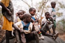Goree, senegal- 6. Dezember 2017: Gruppe von Jungen in ärmlichen Verhältnissen sitzt auf einem Stein in einem ländlichen Dorf. — Stockfoto
