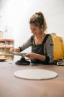 Ritratto di donna bionda che lavora con argilla alla scrivania — Foto stock