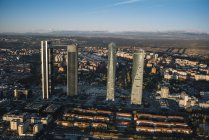 Vista aérea de edificios y rascacielos de la ciudad iluminados por el sol - foto de stock