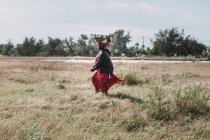 Goree, Senegal- December 6, 2017: Woman carrying basket on head and walking on countryside — Stock Photo