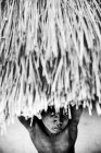 Goree, Senegal - 6 de diciembre de 2017: Retrato de un niño negro mirando desde un bungalow a cámara - foto de stock