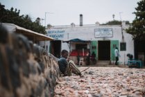 Goree, Сенегалу-6 грудня 2017: Вид збоку з маленьким хлопчиком, жебрацтво сидячи на вулиці невелике містечко африканських. — стокове фото