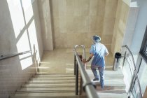Вид сзади на человека в форме, поднимающегося по лестнице в больнице — стоковое фото