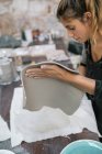 Side view of blonde woman working with clay at workshop — Stock Photo