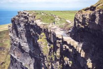 People walking on Moher cliffs on sunny day — Stock Photo
