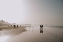 Yoff, Senegal - 6 de diciembre de 2017: Vista a la playa en neblina con gente que pasa tiempo - foto de stock