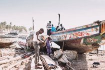 Goree, Senegal- 6 dicembre 2017: bambini africani che giocano vicino alla vecchia barca danneggiata nella giornata di sole . — Foto stock