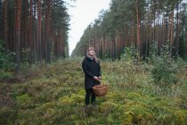 Женщина собирает грибы в лесу — стоковое фото
